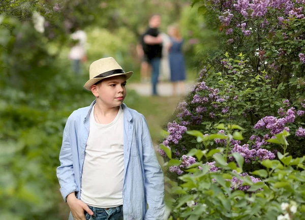 Een jongen met een hoed loopt in de lente botanische tuin waar bloem — Stockfoto