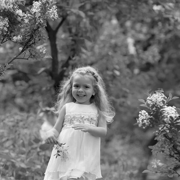 Menina em um vestido branco caminha no jardim botânico primavera — Fotografia de Stock