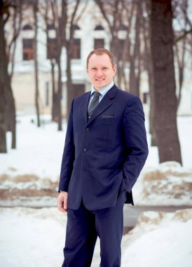 Mavi takım elbiseli, neşeli, genç ve yakışıklı bir iş adamı.