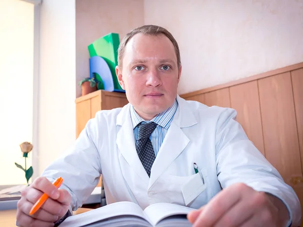 Doktor sedí u stolu na svém pracovišti — Stock fotografie