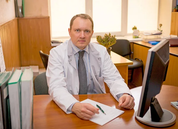 Medico seduto a tavola sul posto di lavoro — Foto Stock