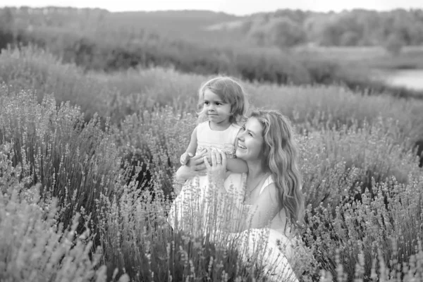 Máma a malá dcera se baví a procházka v levandulovém poli — Stock fotografie