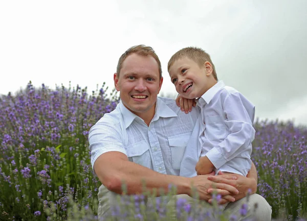 幸せな父親と小さな息子は夏にラベンダー畑で休んでいます — ストック写真