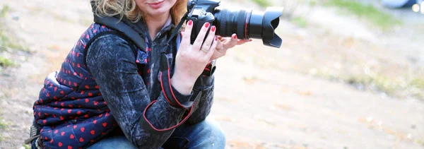 photographer women holding a camera in nature, close up