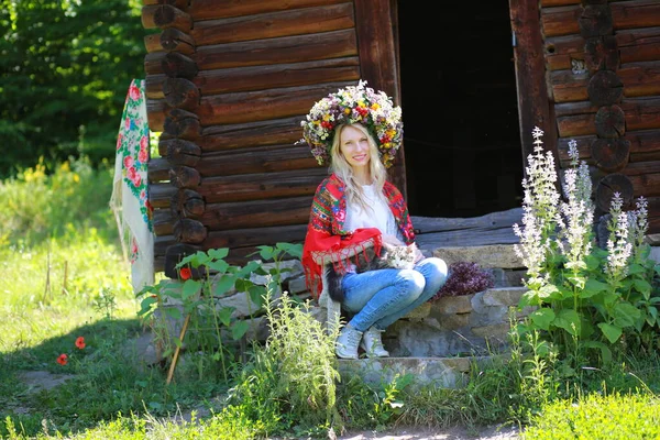 Piękna Młoda Dziewczyna Siedzi Ganku Pobliżu Drewnianego Domu Wieńcu Świeżych — Zdjęcie stockowe