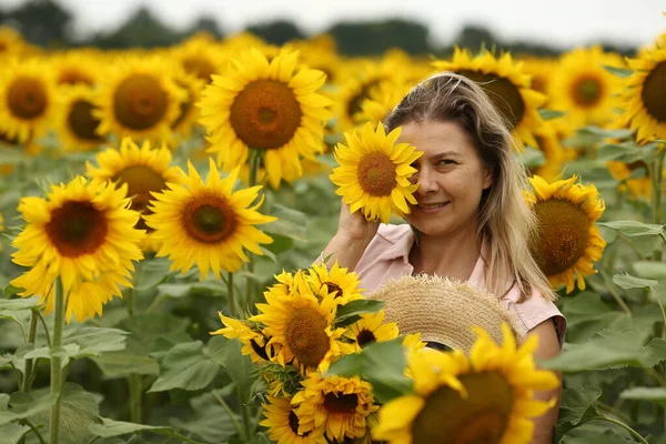 woman in a field with a sunflower. Agriculture concept. Sunflower oil production.