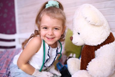 Karantinaya alınmış eğlence. Kafkasyalı tatlı küçük kız evde büyük bir kutup ayısıyla gülüp oynuyor. Koronavirüs 2019-ncov 'a karşı karantina koruması. Ev yalıtımı.