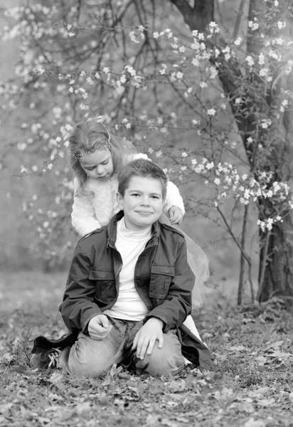 快乐的家庭观念 当地快乐的哥哥和妹妹在公园里玩得很开心 公园里的植物园里开满了盛开的樱花 家庭日 儿童保护日 — 图库照片