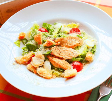Kavrulmuş salata, bıldırcın yumurtası, vişneli domates ve restorandaki bir masada beyaz tabakta ızgara tavuk. Flatlay. Yukarıdan aşağıya.