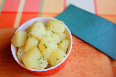  Tahta bir stantta kırmızı bir tabakta haşlanmış patates, yakın plan, düzgün beslenme.