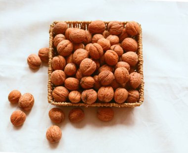 Beyaz arka planda sepetin içinde kısmen ceviz. Flatlay. Yukarıdan aşağıya