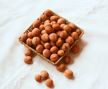 Beyaz arka planda sepetin içinde kısmen ceviz. Flatlay. Yukarıdan aşağıya