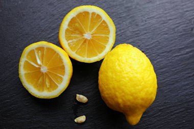 Siyah arka planda turunç sarısı iştah açıcı limonlar. Vitaminler sağlıklı beslenme konsepti. Yakın çekim.