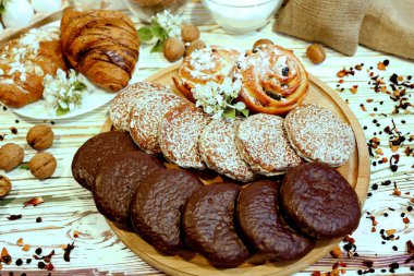 Bir çeşit fırın sahnesi, orijinal Nuremberg zencefilli kurabiyeleri, kekler, ahşap desenli beyaz arka planda içerikli kruvasanlar. Kahve dükkanı reklam konsepti
