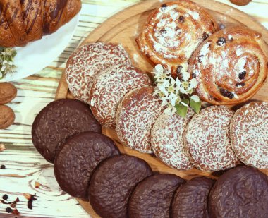 Bir çeşit fırın sahnesi, orijinal Nuremberg zencefilli kurabiyeleri, kekler, ahşap desenli beyaz arka planda içerikli kruvasanlar. Kahve dükkanı reklam konsepti