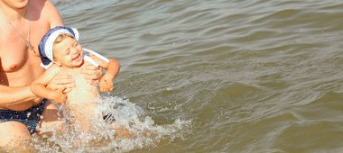 Babamla birlikte denizde küçük mutlu bir kız. Denizde eğlenmek. Gülümse ve gül. Dinlen ve seyahat et. Küçük çocuklarla tatil konsepti. İnsanlar ve reklam kavramı