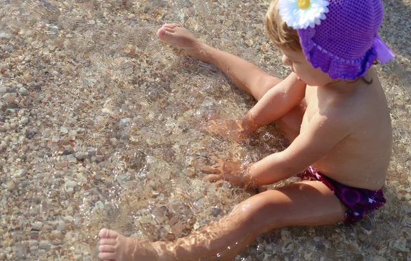 Klein Meisje Paarse Zwembroek Hoed Het Strand Speelt Met Zeestenen — Stockfoto