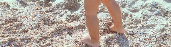 little baby feet walk on the sand at the beach. Rest and travel. Happy family concept. People and advertising concept