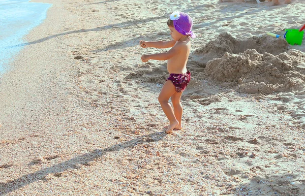 Klein Meisje Paarse Zwembroek Hoed Het Strand Draagt Zeekeien Schelpen — Stockfoto