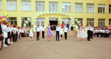 Ukrayna Kiev Mayıs 2019. İlkokul mezunları. Güzel çocuklar açık okul bahçesinde dans ediyorlar. Aileler ve öğretmenler için düzenlenen son çan festivalinde. Modern okul ve eğitim kavramı