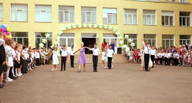 Ukrayna Kiev Mayıs 2019. İlkokul mezunları. Güzel çocuklar açık okul bahçesinde dans ediyorlar. Aileler ve öğretmenler için düzenlenen son çan festivalinde. Modern okul ve eğitim kavramı
