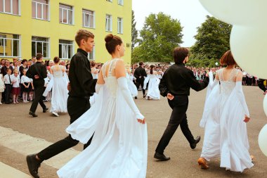Ukrayna Kiev Mayıs 2019. Mezunlar okulu valsi. Mezuniyet sınıfı. Güzel çocuklar açık okul bahçesinde dans ediyorlar. Aileler ve öğretmenler için düzenlenen son çan festivalinde. Modern okul ve eğitim kavramı