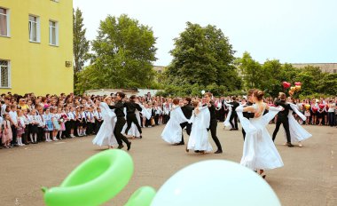 Ukrayna Kiev Mayıs 2019. Mezunlar okulu valsi. Mezuniyet sınıfı. Güzel çocuklar açık okul bahçesinde dans ediyorlar. Aileler ve öğretmenler için düzenlenen son çan festivalinde. Modern okul ve eğitim kavramı