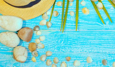 Şapka, güneş gözlüğü, deniz kabukları, deniz taşları mavi akvaryum rengi arka planda plaj aksesuarları olan pankart. Metin için kopyalanma alanı. Seyahat ve turizm. Yaz tatili kavramı.