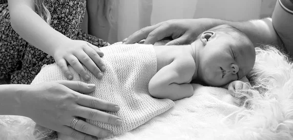 Hands of parents close-up and baby. A newborn boy was born in a happy family. Family concept.black and white portrait