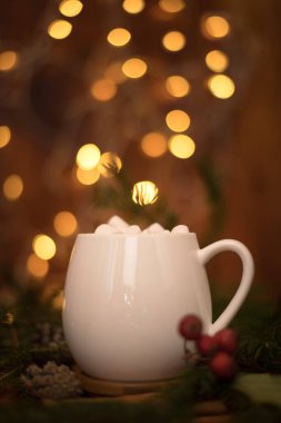 Beyaz bir fincanda kakao içmek, arka planda marşmelov, sıcak Noel içeceği.