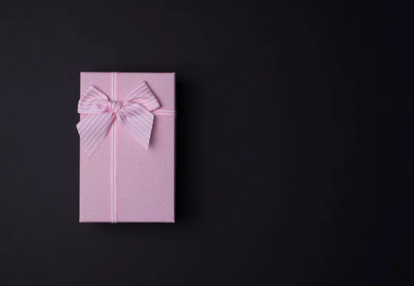 검은 배경에 활 이 있는 직사각 형 분홍색 선물 상자, 위쪽을 바라봄 — 스톡 사진