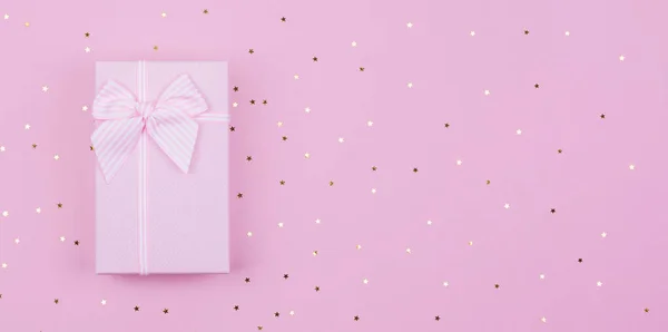 Rózsaszín Ajándék vagy jelen doboz és csillagok konfetti rózsaszín háttérrel. Lapos laikus kompozíció születésnapjára Újév, másolási szakasz — Stock Fotó