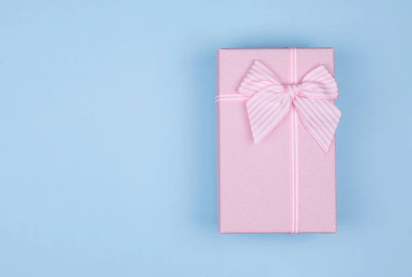 분홍색 직사각 형 선물 상자에 파란색 배경에 핑크 리본 이 있습니다. 3 월 8 일, 발렌타인데이 생일 선물. 위에서 본 모습. 복사 공간 — 스톡 사진
