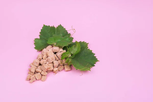 The ctreative sugar content of grapes. Bunch of grapes made of sugar on a pink background. Mock up
