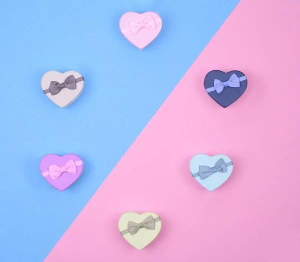 Pequeñas cajas de regalo multicolores corazones sobre fondo azul y rosa, vista superior, espacio de copia — Foto de Stock