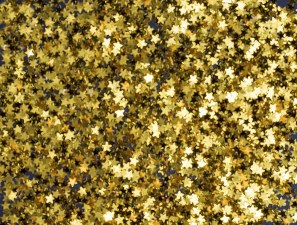 Golden Christmas stars on black background, blured, defocus — Stock Photo, Image
