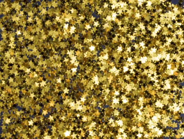 Golden Christmas stars on black background, blured, defocus — ストック写真