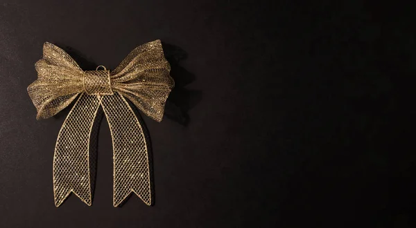 Big golden bow isolated on black Christmas decoration, mock up, copy space — Stock Photo, Image