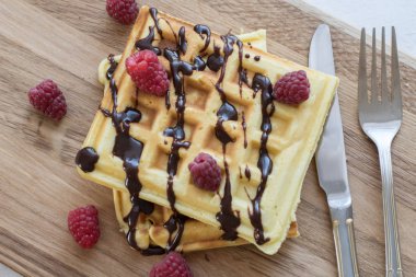 Ahşap bir Tahta üzerinde çikolata ve çilek ile iki Viyana waffle