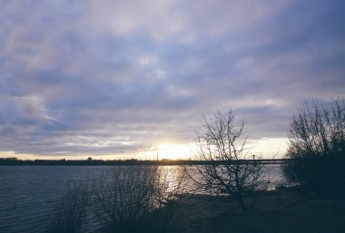 Gün batımı Daugava Nehri üzerinde, Riga, Letonya. Ekim 'de şehir manzarası.