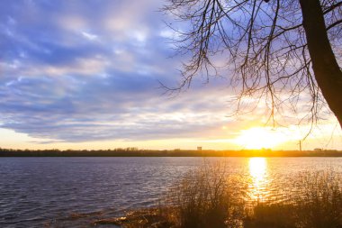 Gün batımı Daugava Nehri üzerinde, Riga, Letonya. Ekim 'de şehir manzarası.