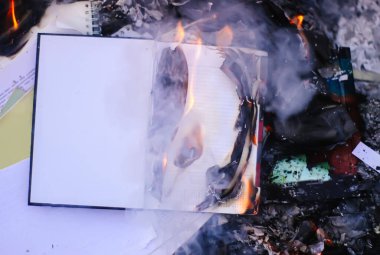 Yeşil yaz çimlerinde yanan eski bir not defteri..