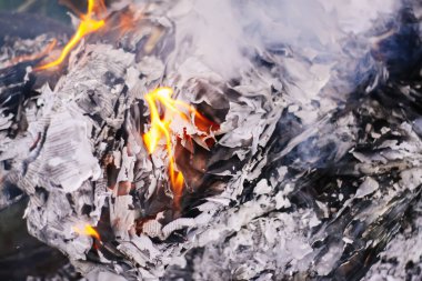 Açık havada yeşil yaz çimlerinde kağıt yanıyor..