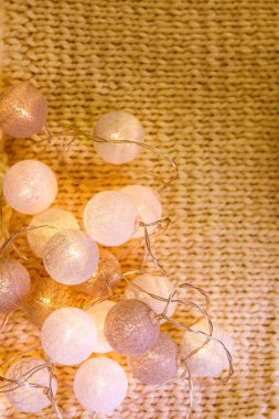 Noel ışıkları, örülmüş kumaş arkaplanda yuvarlak fenerlerle süslenir..