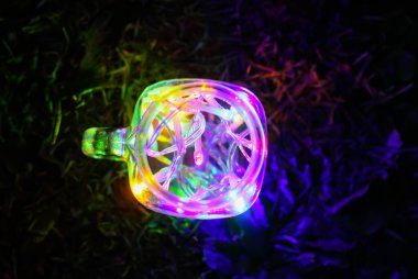 Gece karanlığında cam kavanozda parlak renkli çelenk ışıkları olan bir kart..