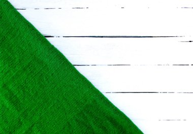 Beyaz yaşlı ahşap arka planda yeşil örülmüş yün ekose..