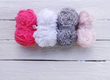 Beyaz ahşap masada renkli iplik topları