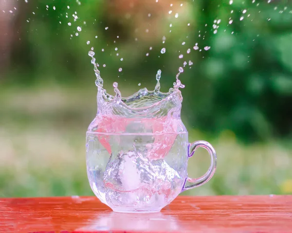 Всплеск Прохладной Пресной Воды Кубиком Льда Прозрачной Стеклянной Чашке Таблице — стоковое фото