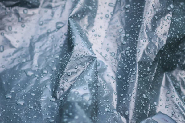 雨の滴と湿った砕いたプラスチックカバー表面 — ストック写真