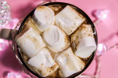 Seramik kupa sıcak sıcak kakao içeceği yumuşak pembe arka planda eriyen tatlı marşmelov.